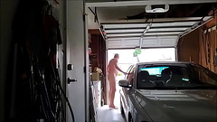 Old man naked in garage daytime door open cars drive by Thumb